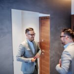 Man in suit practicing interview skills in front of the mirror